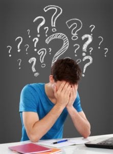 Tired of studying. confused young man covering his head while sitting. with question mark on top of him