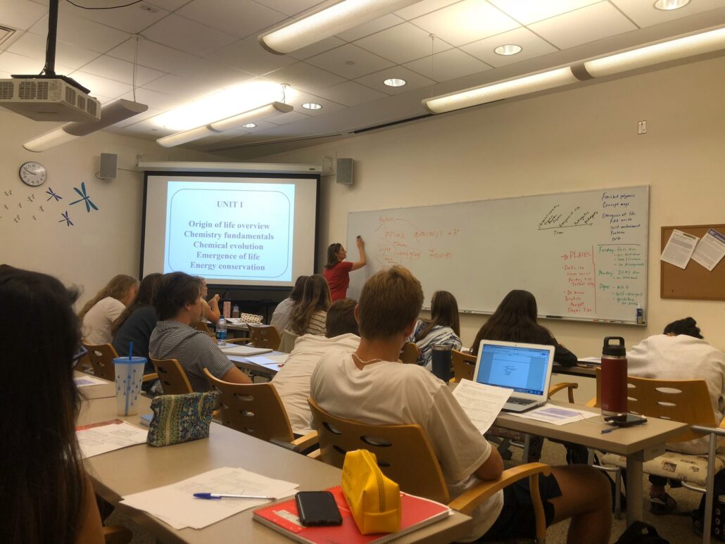 A Denison professor teaching an introductory science class as students take notes